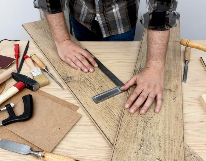 Tuttofare che prende le misure su una tavola di legno